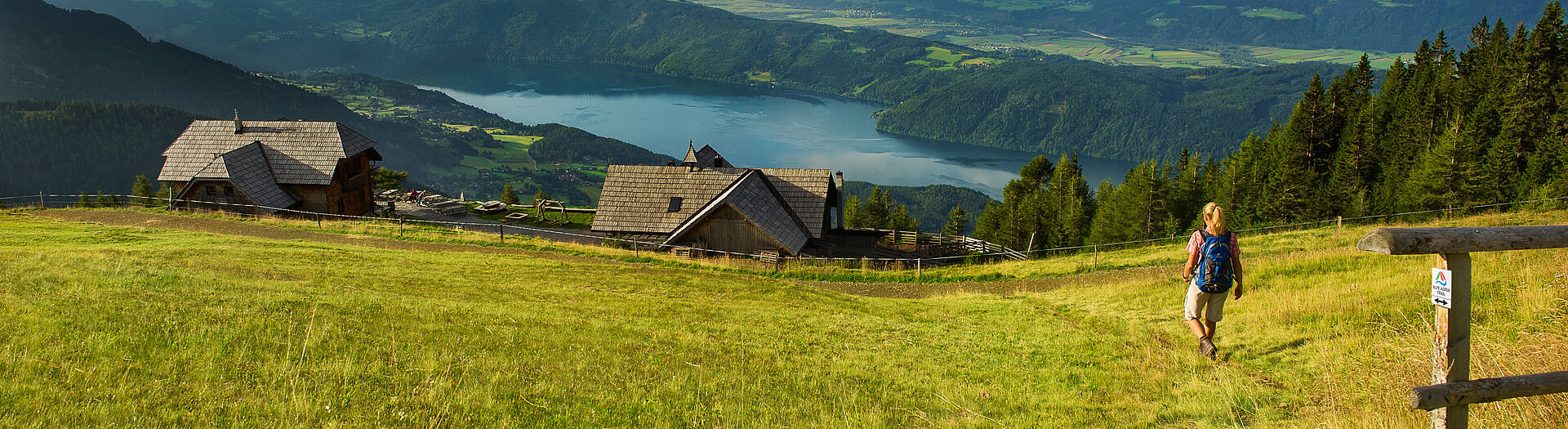 Wanderer auf dem Alpe Adria Trail mit Blick auf See