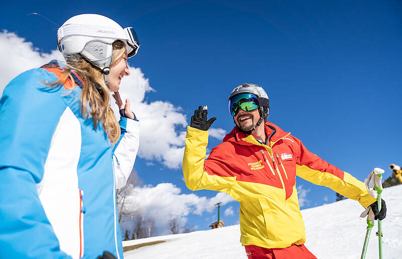 Skilehrer klatscht mit Schülerin ab