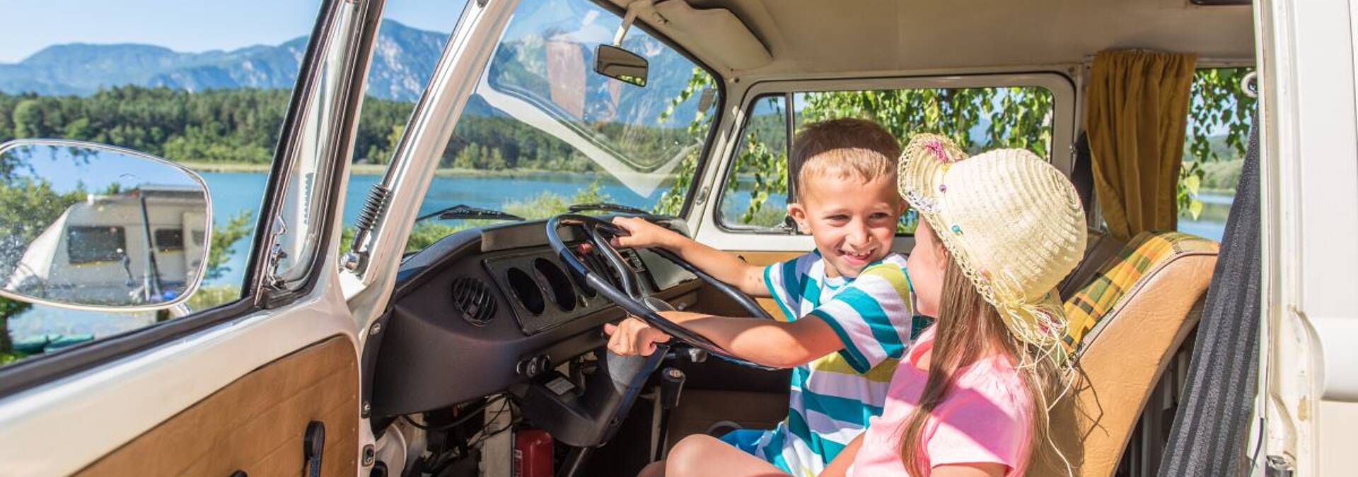 Kinder sitzen voller Freude im Wohnmobil.