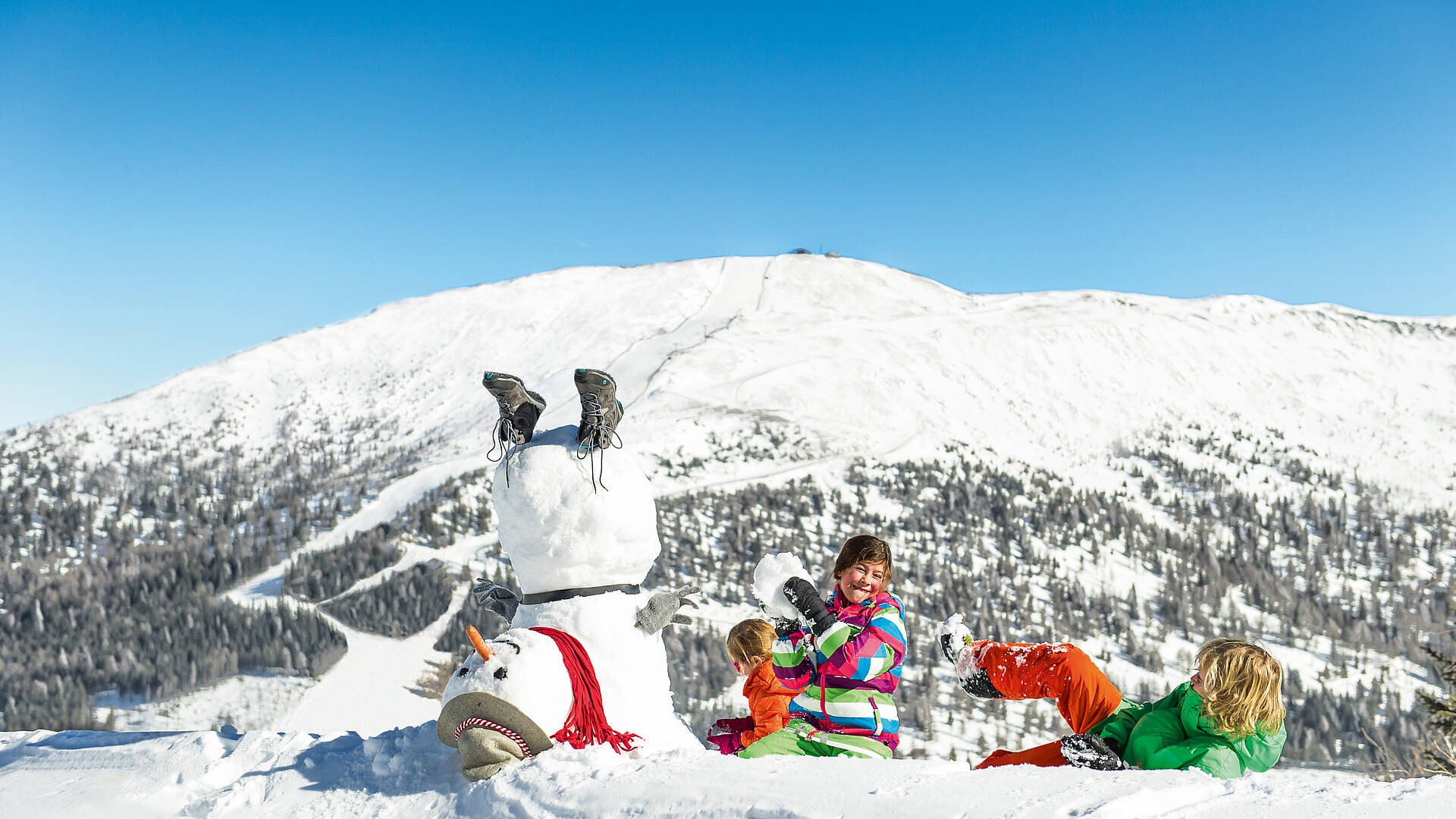 Katschberg_Kinder haben Spaß im Schnee mit Schneemann 